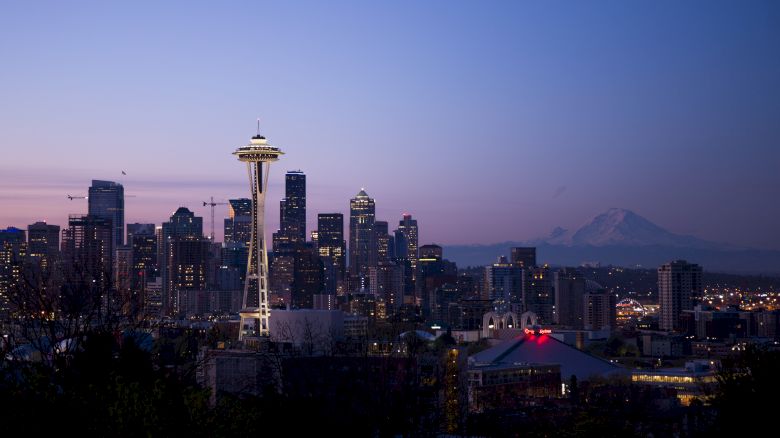 A stunning view of Seattle's skyline at dusk, showcasing the Space Needle and city buildings with Mount Rainier in the background.